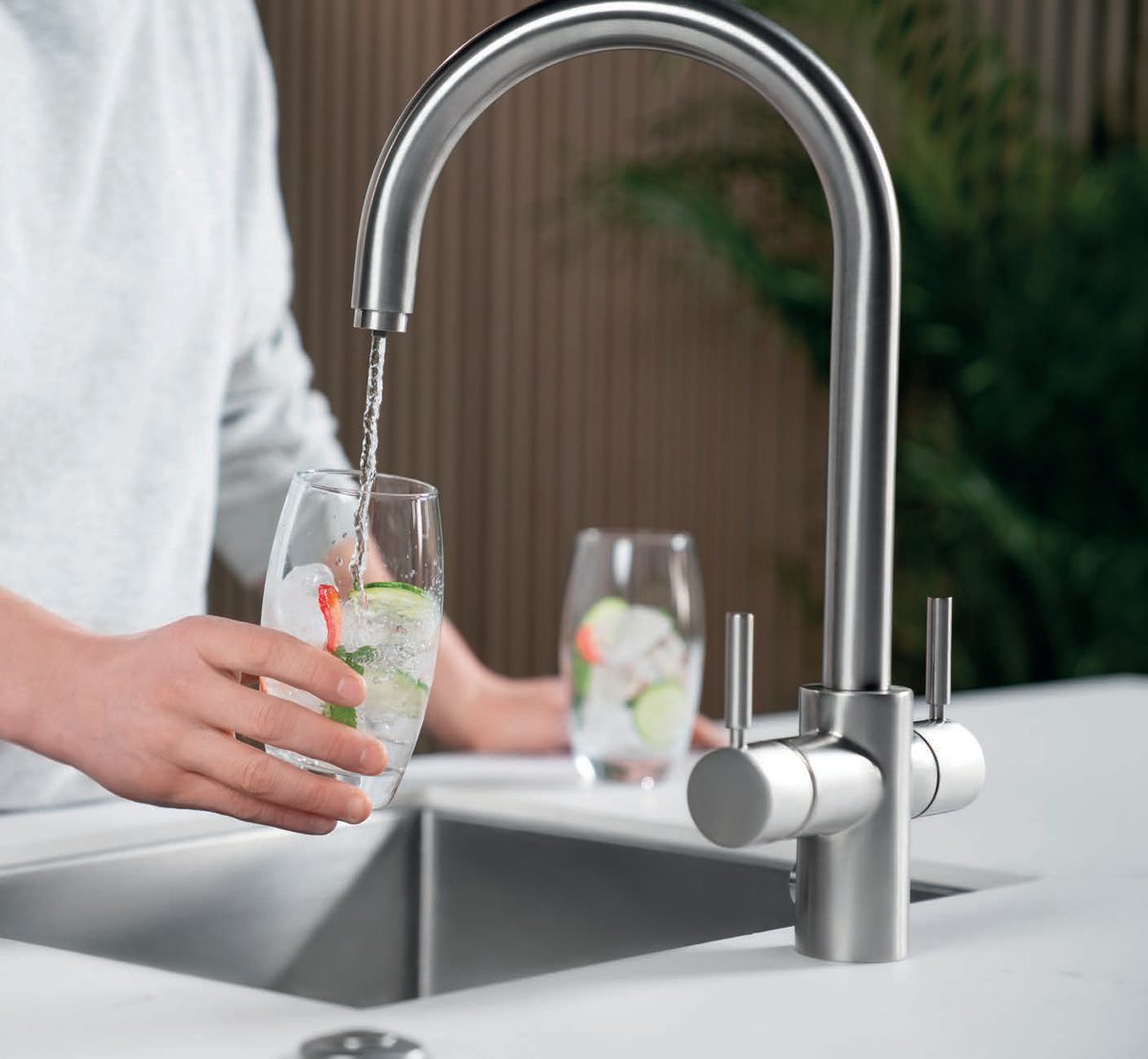 Grifo InSinkErator 4N1 sirviendo agua fr&iacute;a filtrada en un vaso